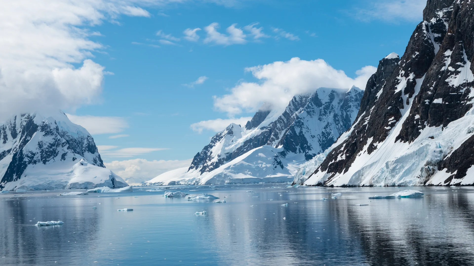 Snow-capped peaks reflected in the calm water of the Lemaire Channel, Antarctica