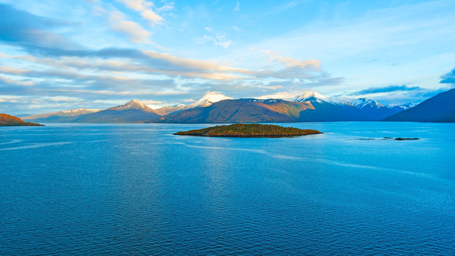 Calm waters and snow-capped mountains of the Strait of Magellan, Chile