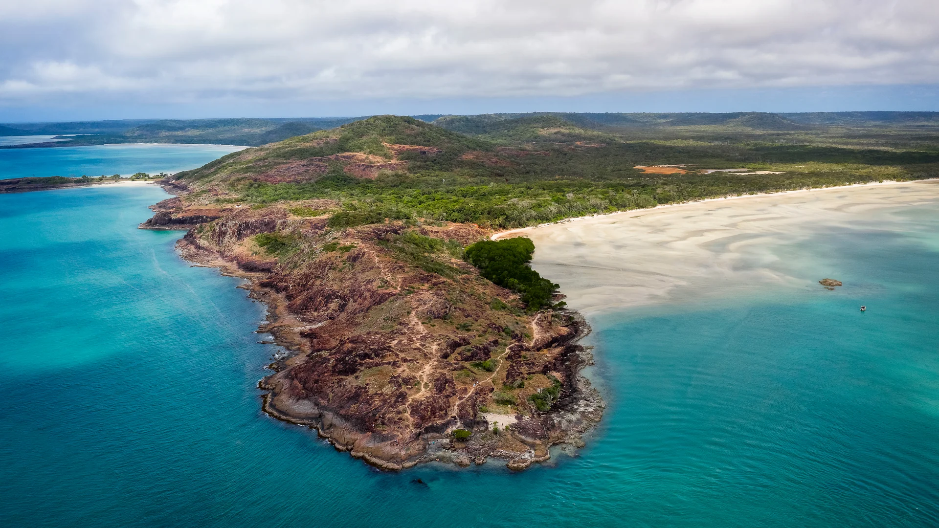 Red-cliff Cape York island with turquoise beach