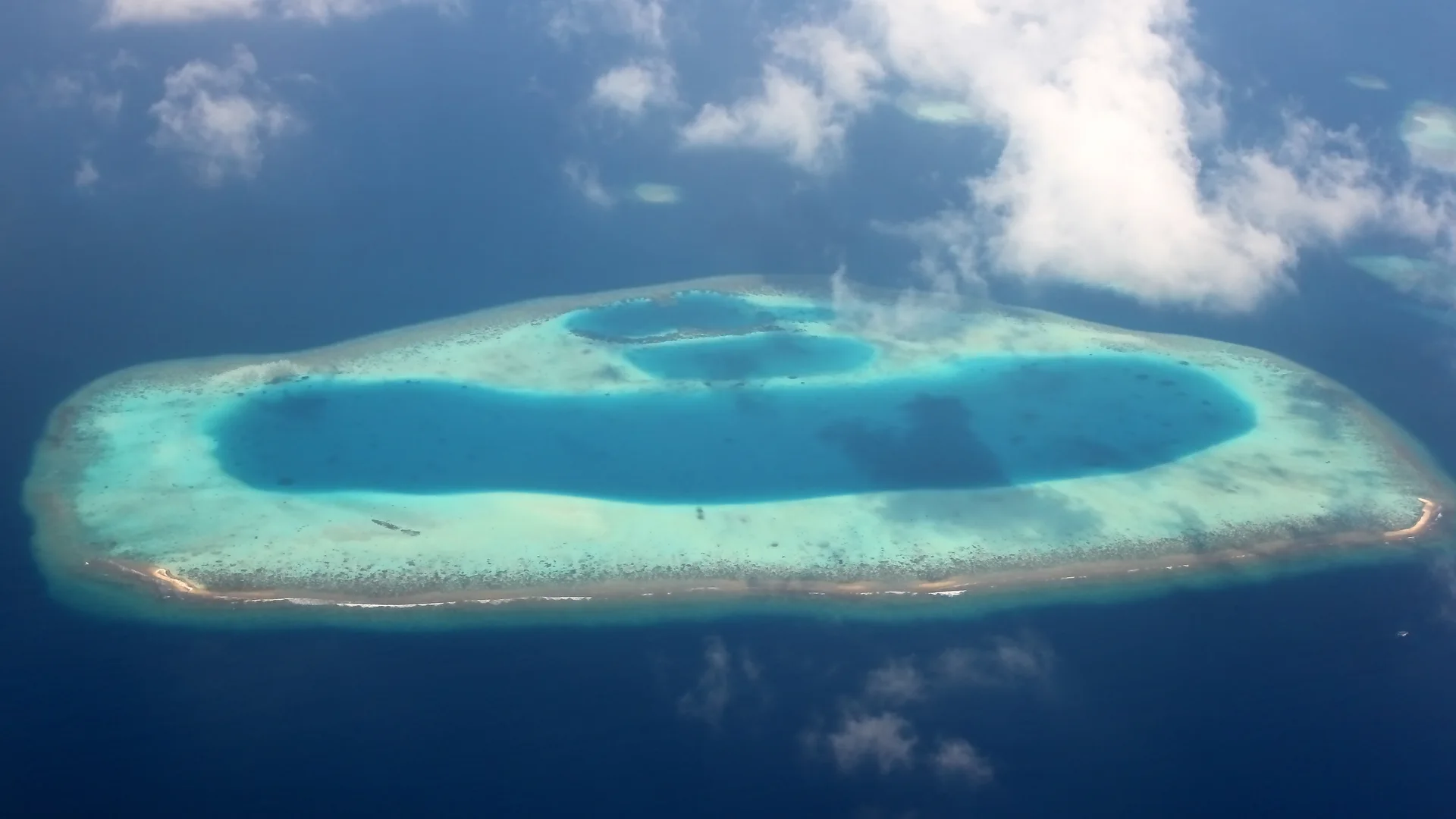 Aerial of a turquoise coral atoll ring