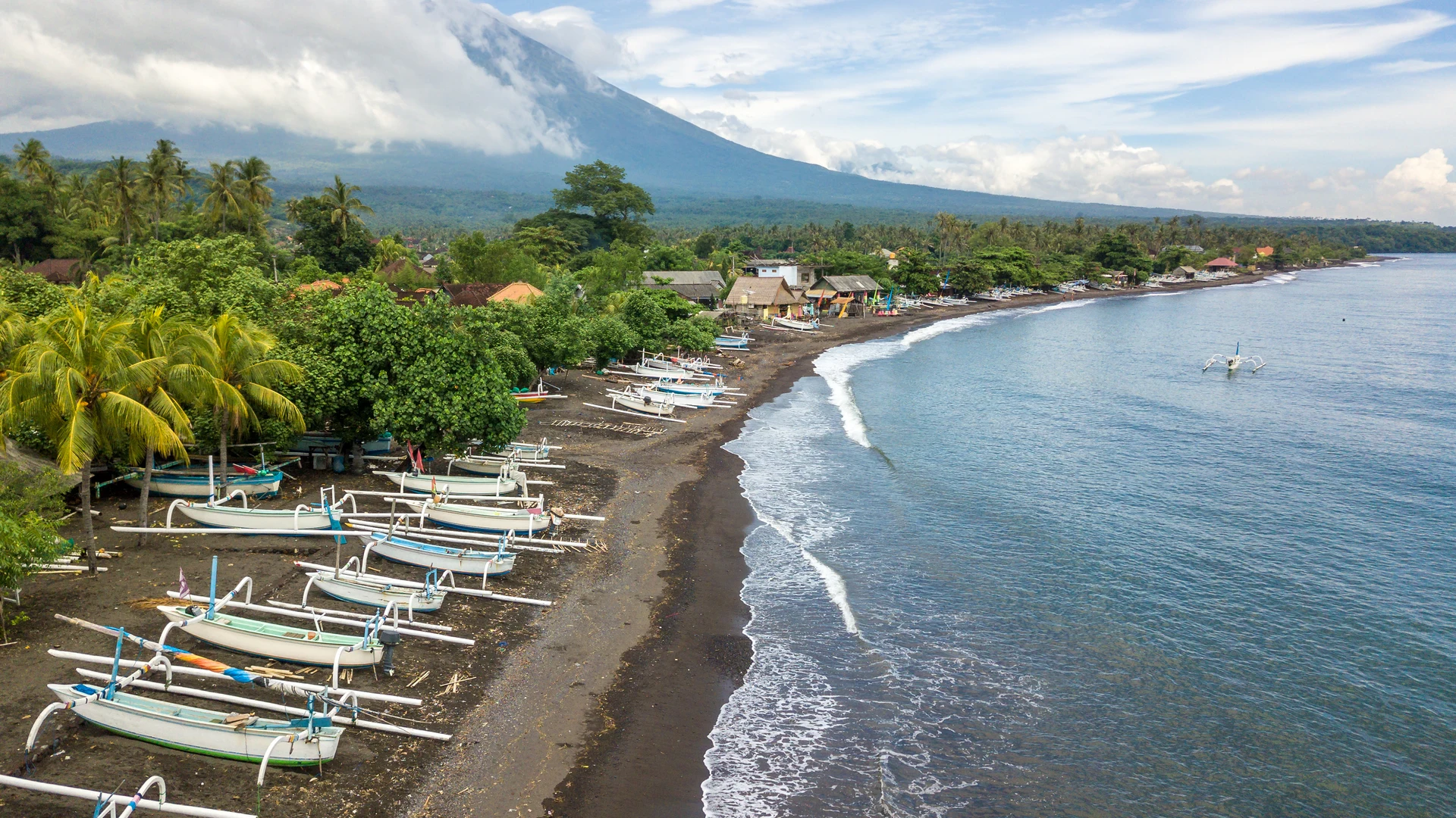 Black-sand beach with fishing boats and Mount Agung, Kubu, East Bali